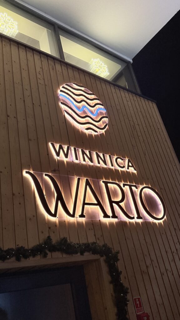 Logo winnicy warto na ścianie winiarni 